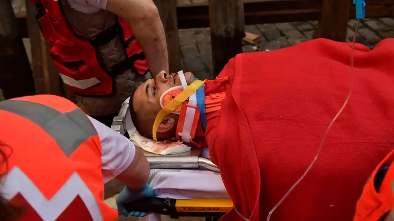 Traslado del hombre de 30 años natural de Alaska y golpeado por un cabestro en la calle Mercaderes en el tercer encierro de San Fermín 2018 con toros de Cebada Gago. (AP Photo/Alvaro Barrientos)