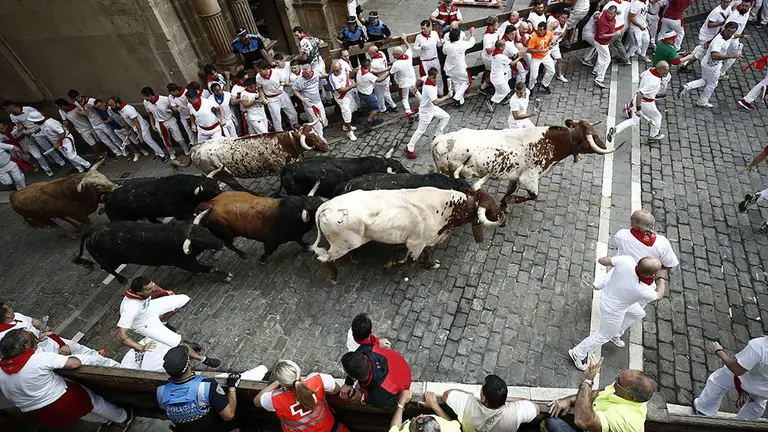 GRAF7047. PAMPLONA, 10/07/2018.- Los toros de la ganadería gaditana de Fuente Ymbro suben la cuesta de Santo Domingo hacia el Ayuntamiento junto a mansos y mozos durante el cuarto encierro de los Sanfermines 2018. EFE/Jesús Diges