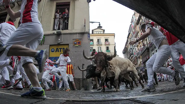 GRAF8625. PAMPLONA, 12/07/2018.- Los toros de la ganadería madrileña de Victoriano del Río Cortés a su paso por la curva de Mercaderes durante el sexto encierro de los Sanfermines 2018 que ha sido veloz y limpio sin que los servicios asistenciales tengan constancia de heridos por asta. EFE/Rodrigo Jiménez