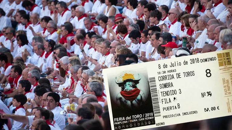 Una entrada para la plaza de toros de Pamplona junto a una imagen del ambiente en sombra durante una corrida de los Sanfermines NAVARRACOM