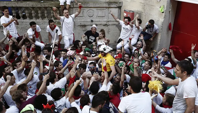GRAF743. PAMPLONA, 15/07/2018.- Para algunos, los Sanfermines terminan oficialmente hoy con la celebración del llamado "Encierro de la Villavesa" en el que se simula todo el ritual del encierro como si se tratara de uno de los habituales durante las fiestas. Desde hace años al suspenderse el recorrido de la villavesa, es una persona que emulando al ex ciclista navarro Miguel Induráin realiza el encierro subido sobre una bicicleta hasta la entrada a la Plaza de Toros donde es aclamado por los cientos de jóvenes que le acompañan. EFE/Jesús Diges