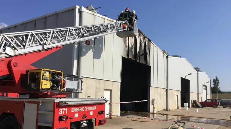Bomberos actúan en la nave incendiada en Artajona.