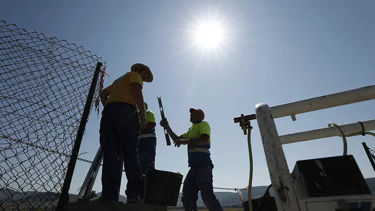 Varios trabajadores colocan una señal topográfica junto a la balsa de Zolina, cerca de Pamplona, en una jornada donde la Agencia Estatal de Meteorología (Aemet) ha dado aviso amarillo para Navarra por el aumento de las temperaturas, que pueden llegar hasta 38 grados en la Ribera del Ebro, a 36 en el centro de la comunidad y a 34 en Pirineos. La Aemet añade que el cielo estará en esta jornada despejado y el viento soplará flojo de dirección variable, con predominio del norte y noroeste, y con cierzo flojo en la Ribera. EFE/Jesús Diges