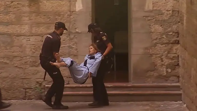 Los agentes llevan en volandas a la acusada tras negarse a caminar. EE