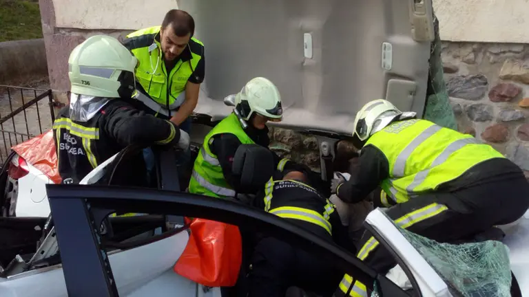 Los bomberos se afanan en desatrapar al conductor herido tras chocar con una vivienda en Oronoz
