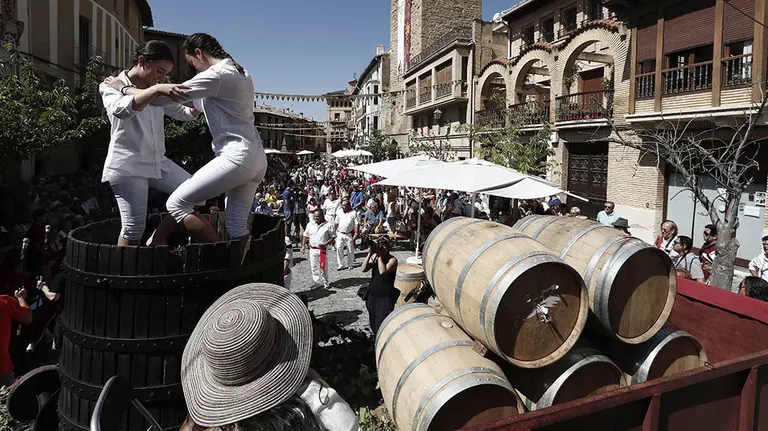 GRAF4533. OLITE (NAVARRA), 02/09/2018.- Dos jóvenes pisan dentro de una barrica racimos de uva, hoy en Olite (Navarra) dentro de los actos conmemorativos del XXVIII Día de la Vendimia de Navarra, organizados por la Cofradía del Vino de Navarra, con los que se celebra cada año la eclosión de una nueva cosecha. EFE/Jesús Diges