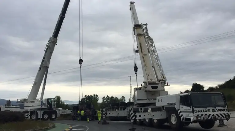 Una grúa retira un camión volcado en la rotonda de acceso a la autovía A-10 en Alsasua. POLICÍA FORAL