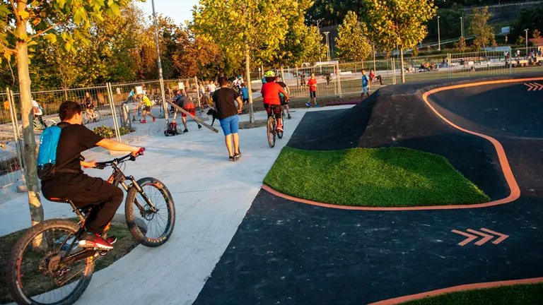 La pista de pump track de Trinitarios se llena de ciclistas y patinadores mientras permanece vallada y sin inaugurar, a falta de realizar los trabajos finales. MIGUEL OSÉS