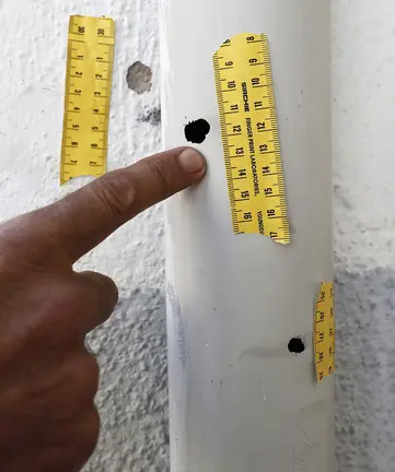 GRAF6285. PAMPLONA (ESPAÑA), 19/09/2018.-Una persona señala las marcas del impacto de las postas en la tuberia de una vivienda de Caseda donde ayer tres personas fallecieron en un tiroteo. El Ayuntamiento de Cáseda ha decretado tres días de luto oficial y ha colocado crespones negros en las banderas por la muerte a tiros de tres personas en una reyerta entre dos familias, un suceso por el que hay tres personas detenidas. En un comunicado difundido hoy, el Ayuntamiento lamenta el suceso que acabó con la vida de José Jiménez, vecino de Cáseda de 29 años y padre de una niña de 2 años, su hermano de 16 años y su padre Fermín de 50 años, estos dos últimos vecinos de Eslava. EFE/Jesús Diges