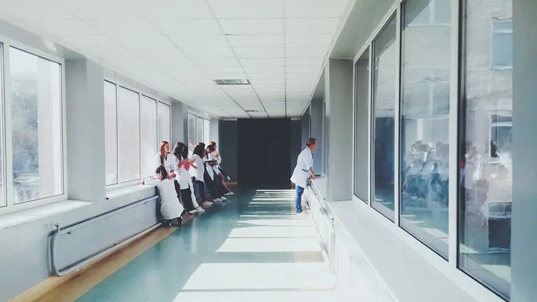 Varios médicos y enfermeras esperan en el pasillo de un hospital junto a unos pacientes ARCHIVO