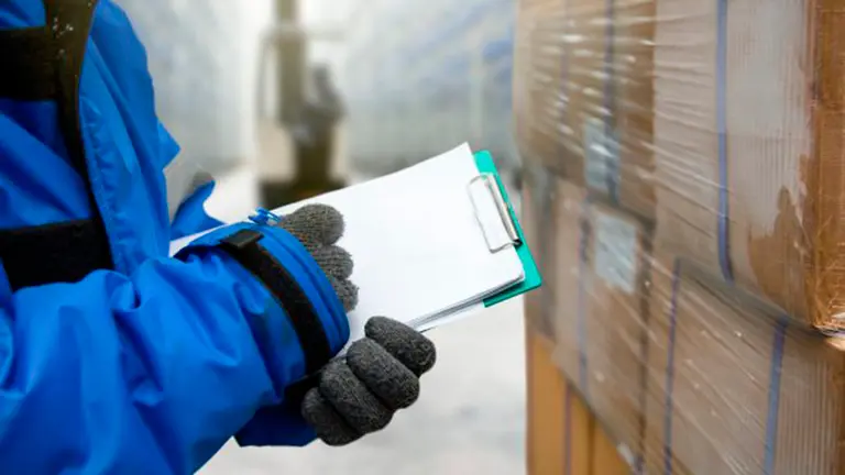 Un trabajador toma nota tras recibir la mercancia desplazada al almacén de una fábrica ARCHIVO