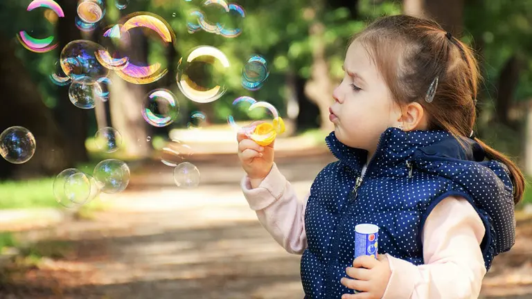 Una niña haciendo pompas de jabón
