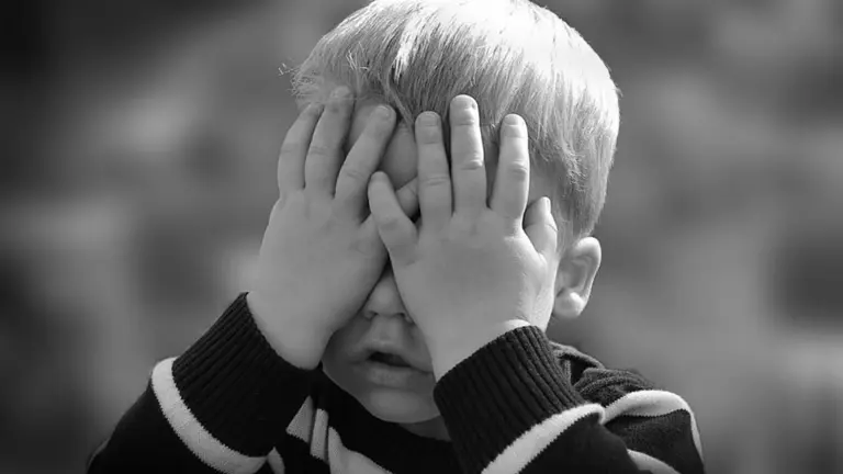 Niño tapándose los ojos