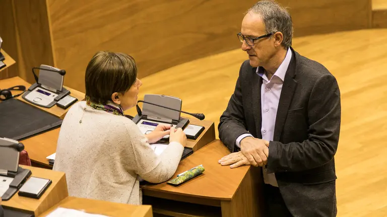 Uxue Barkos (Geroa Bai) y Adolfo Araiz (Bildu) conversan minutos antes del pleno del Parlamento de Navarra. IÑIGO ALZUGARAY