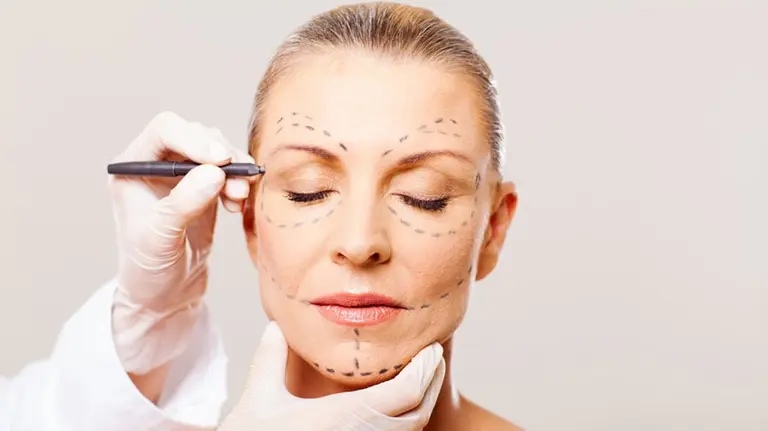 Imagen de una paciente atendida por un médico durante un tratamiento de cirugía estética ARCHIVO