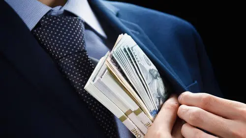 Un hombre se guarda el dinero en el bolsillo