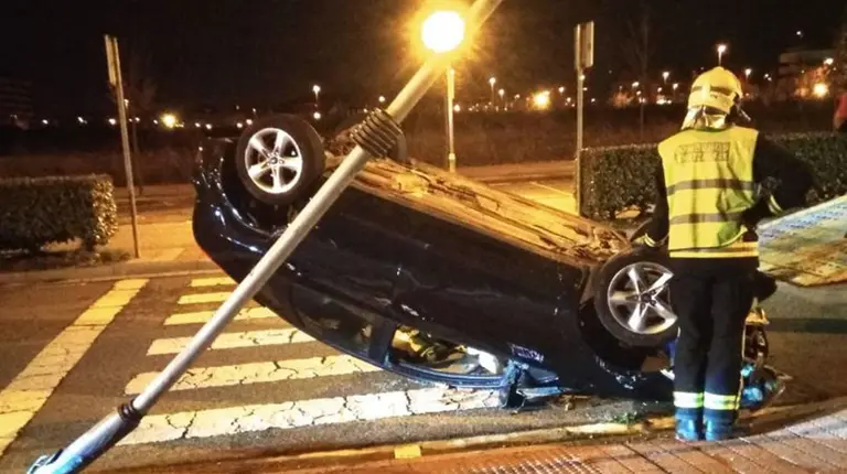 Imagen de la impactante salida de vía registrada en la calle Roma de Ripagaina donde un conductor que circulaba borracho ha acabado volcando su coche BOMBEROS DE NAVARRA