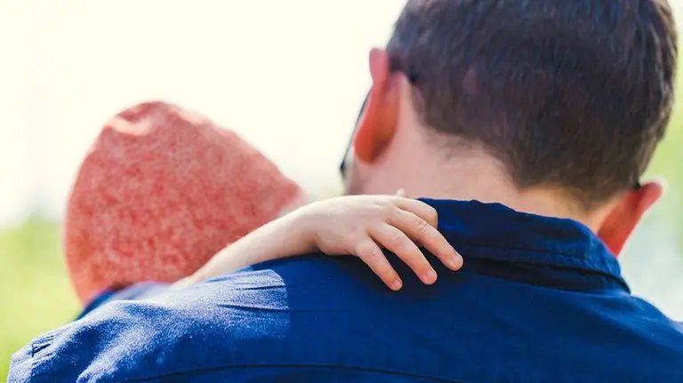 Un padre sujeta en brazos a un bebé ARCHIVO