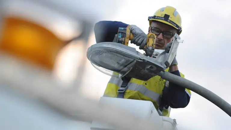 Un trabajador instala una farola con un nuevo sistema de iluminación ARCHIVO