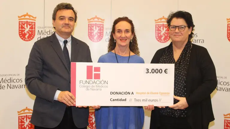 Rafael Teijeira, presidente del Colegio de Médicos, y Julia Alonso, coordinadora del coro del Colegio, entregan el cheque a Marga Iraburu (centro) CEDIDA