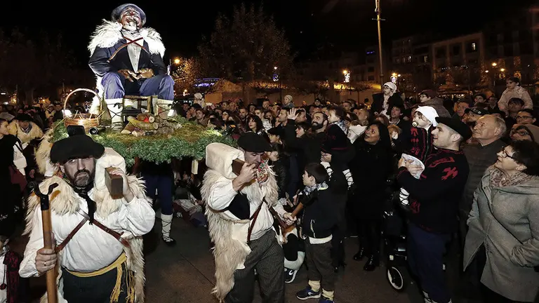 Miles de personas cargadas de ilusiones, adultos, jóvenes y niños, han recibido esta tarde en Pamplona a Olentzero, al que han acompañado en su recorrido por la ciudad y en el homenaje que le ha tributado el Ayuntamiento. Como sucede desde 2015, el viejo carbonero sido recibido por el alcalde en la plaza consistorial. Allí, Joseba Asiron (d), acompañado de concejales y de la banda de música municipal La Pamplonesa, ha impuesto a Olentzero un gran pañuelo de cuadros azul y blanco, típico de su atuendo, con el escudo de la cuidad en reconocimiento y recuerdo. EFE/Jesús Diges