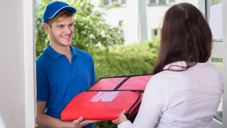 Imagen de un repartidor entregando una pizza a domicilio ARCHIVO