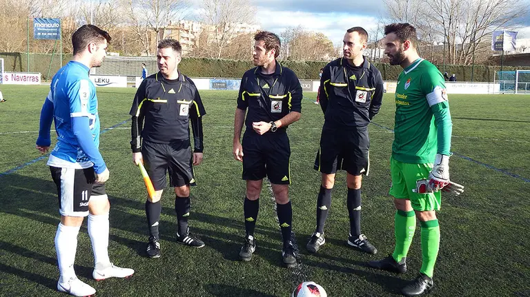 Trio arbitral y capitanes del partido Huarte - Peña Sport en el campo de Areta.
