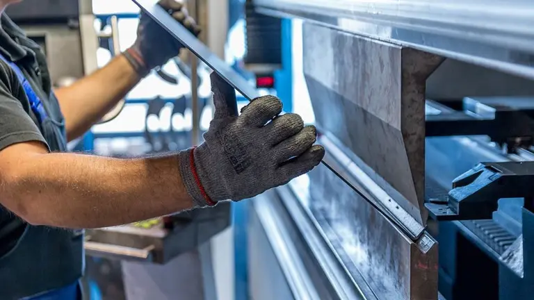 Un trabajador de una empresa manipula metal ARCHIVO