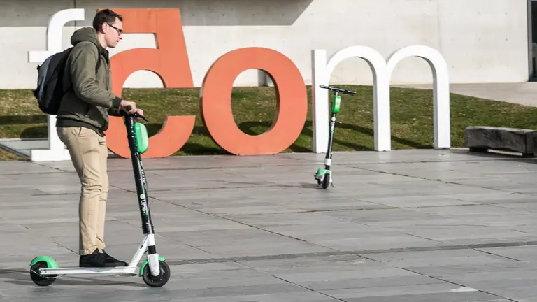 Un joven utiliza un patinete eléctrico de alquiler en el campus de la Universidad de Navarra (01). IÑIGO ALZUGARAY