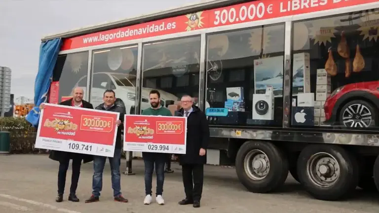 Algunos de los ganadores de La Gorda de Navidad posan con la macrocesta que sortea cada año el El Villa Castejón Foto EL VILLA CASTEJÓN