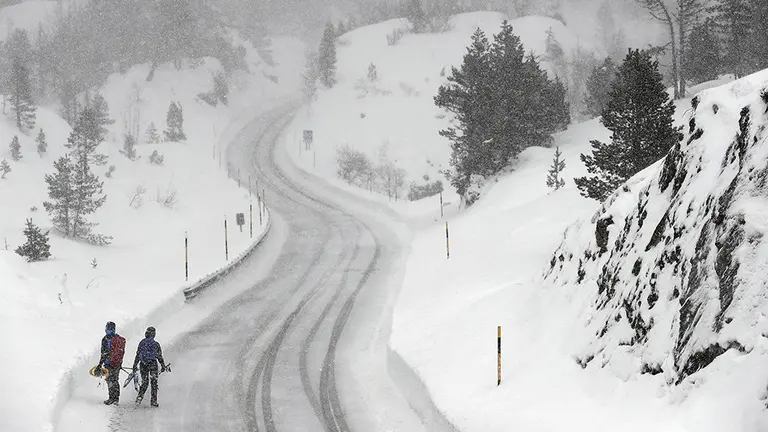 GRAF6410. BELAGOA (NAVARRA, 27/01/2019. Dos personas caminan por la N-137 en la zona de El Ferial en una jornada donde un nuevo temporal de nieve arrecia fundamentalmente en el norte de la Comunidad Foral. La AEMET anuncia para los próximos días copiosas nevadas en la zona. EFE/Jesús Diges