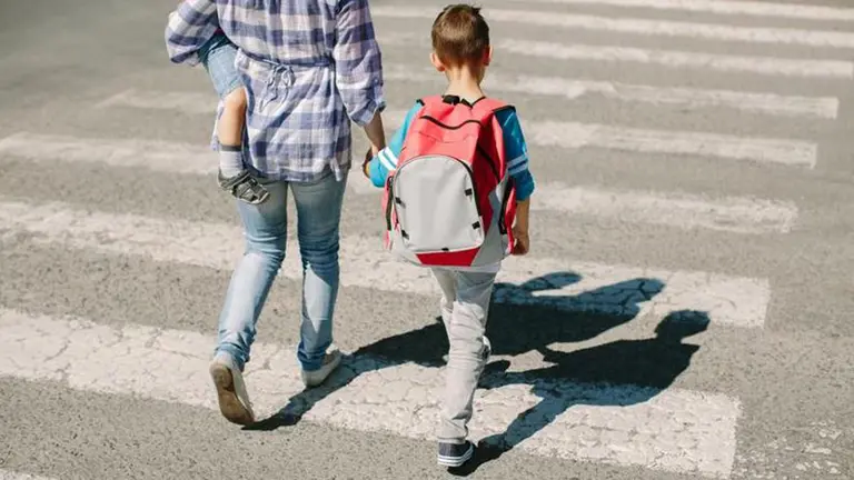 Un niño cruza un paso de cebra junto a su madre. ARCHIVO