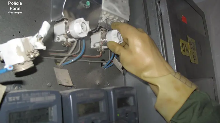 Los agentes de la Policía Foral revisan los contadores alterados por unos okupas en un inmueble de Olite para tomar ilegalmente electricidad POLICÍA FORAL