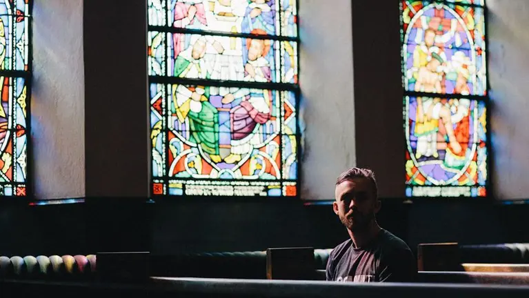 Un joven rezando dentro de una iglesia ARCHIVO