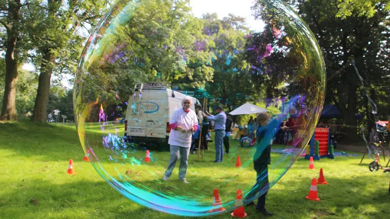 Imagen de una excursión escolar en la que alumnos y profesores participan con juegos, pruebas físicas y pompas de jabón en una zona de bosque ARCHIVO