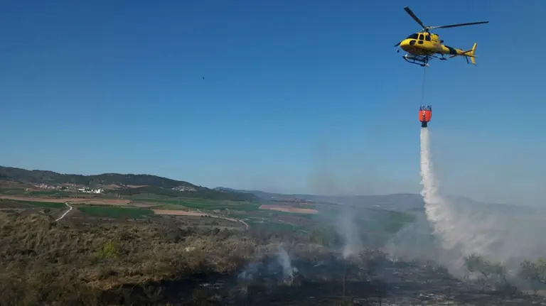 Un helicóptero colabora en las labores de extinción de un incendio en Mañeru