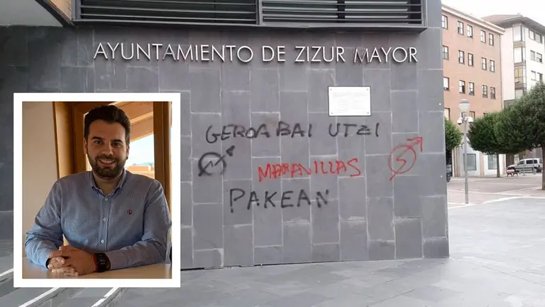 El alcalde de Zizur Mayor, Jon Gondán, junto a las pintadas aparecidas en el consistorio el pasado año