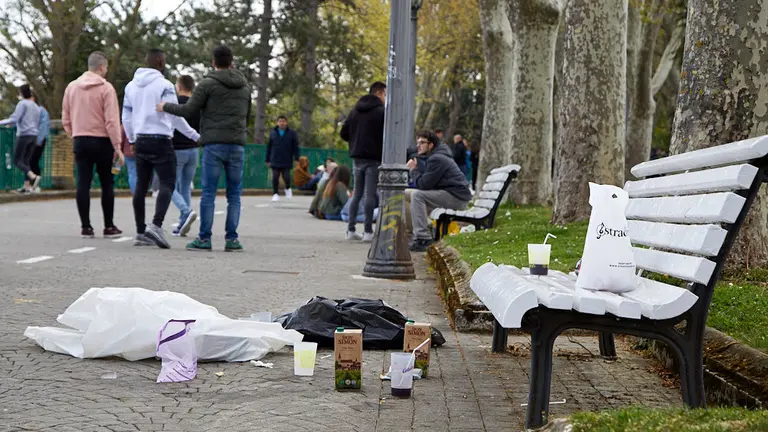 Los jóvenes universitarios 'calientan motores' para la carpa en un botellón improvisado en el parque de la Medialuna de Pamplona (19). IÑIGO ALZUGARAY