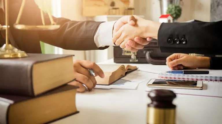 Una abogado se estrecha la mano junto a su cliente ARCHIVO