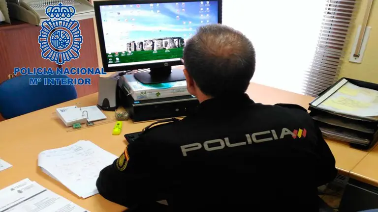 Un Policía Nacional atiende en una oficina. CEDIDA