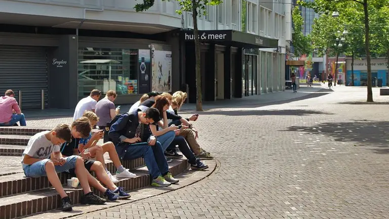 Varios adolescentes atentos a su teléfono móvil ARCHIVO