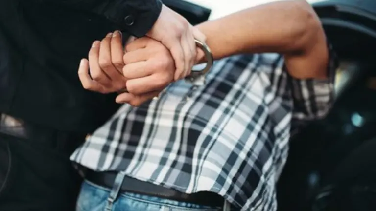 Un policía arresta a una persona y la introduce en el coche policial ARCHIVO