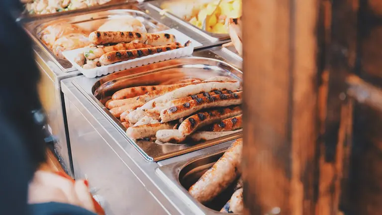 Imagen de varias salchichas y embutido hecho a la plancha en la cantina de un comedor escolar ARCHIVO