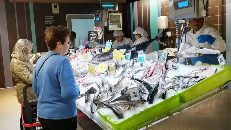 Varios trabajadores atienden a un grupo de clientes en la sección de pescadería del nuevo modelo de tienda de Eroski abierto en Burlada IMAGEN CEDIDA