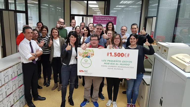 Trabajadores de TCC junto al cheque donado a varias asociaciones relacionadas con la salud. CEDIDA