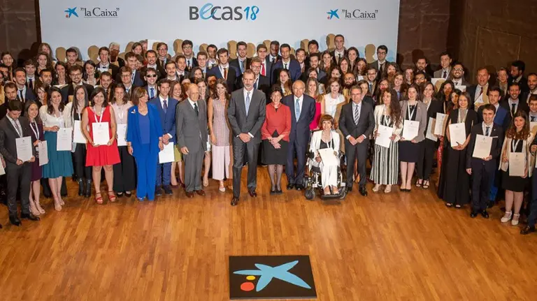 Los reyes de España; Isidro Fainé, presidente de “la Caixa”; Jaume Giró, director general de &#34;la Caixa”; Isabel Celaá, ministra de Educación y Formación Profesional en funciones; y Paloma Adrados, presidenta de la Asamblea de Madrid, junto a algunos de los estudiantes seleccionados, durante el acto de entrega de las becas de “la Caixa”, en CaixaForum Madrid. CEDIDA