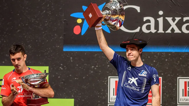 El pelotari Iker Irribarri (d) levanta el trofeo tras derrotar a Mikel Urrutikoetxea (i) en la final del Campeonato Manomanista 2019 que se ha celebrado en el Front..n Bizkaia de Bilbao. EFE/JAVIER ZORRILLA.