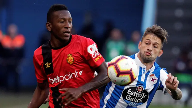 El defensa ecuatoriano del Mallorca Pervis Estupiñán (i) pelea un balón con el centrocampista argentino del Deportivo Fede Cartabia durante el partido de ida de la eliminatoria final de ascenso a Primera División que se disputa esta noche en el estadio de Riazor. EFE/Cabalar.