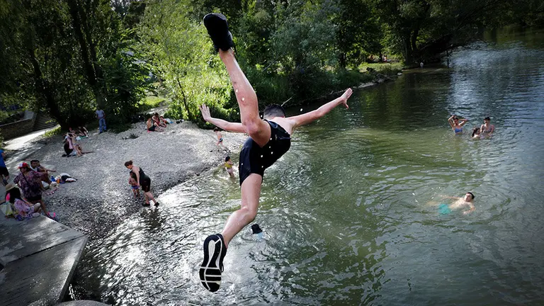 GRAF4784. PAMPLONA (NAVARRA), 26/06/2019.- Varios jóvenes combaten el calor este miércoles en el río Arga a su paso por Pamplona, donde las altas temperaturas extremas continuarán como en la mayor parte de España, hasta el próximo lunes. EFE/Villar López.