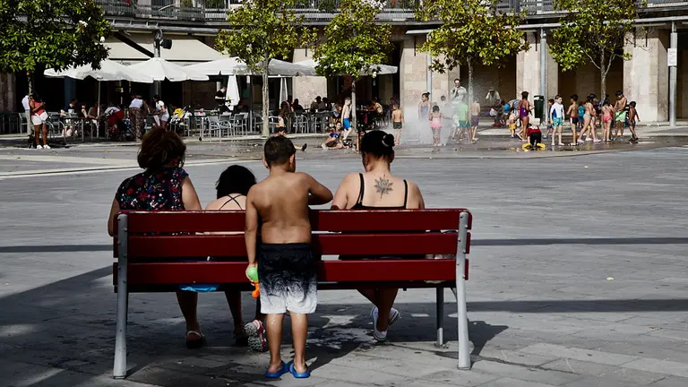 Unos niños juegan en la 'fuente de chorros' de la Plaza de Yamaguchi durante la primera ola de calor del verano en Pamplona. IÑIGO ALZUGARAY